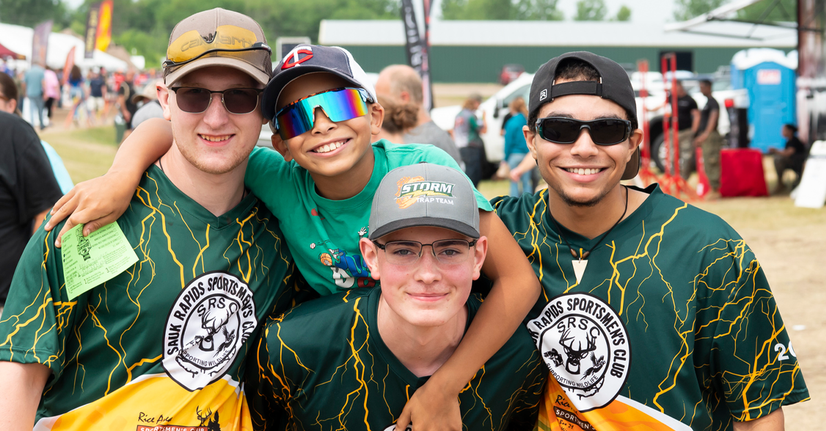 Four young men posing for a photo at an event.